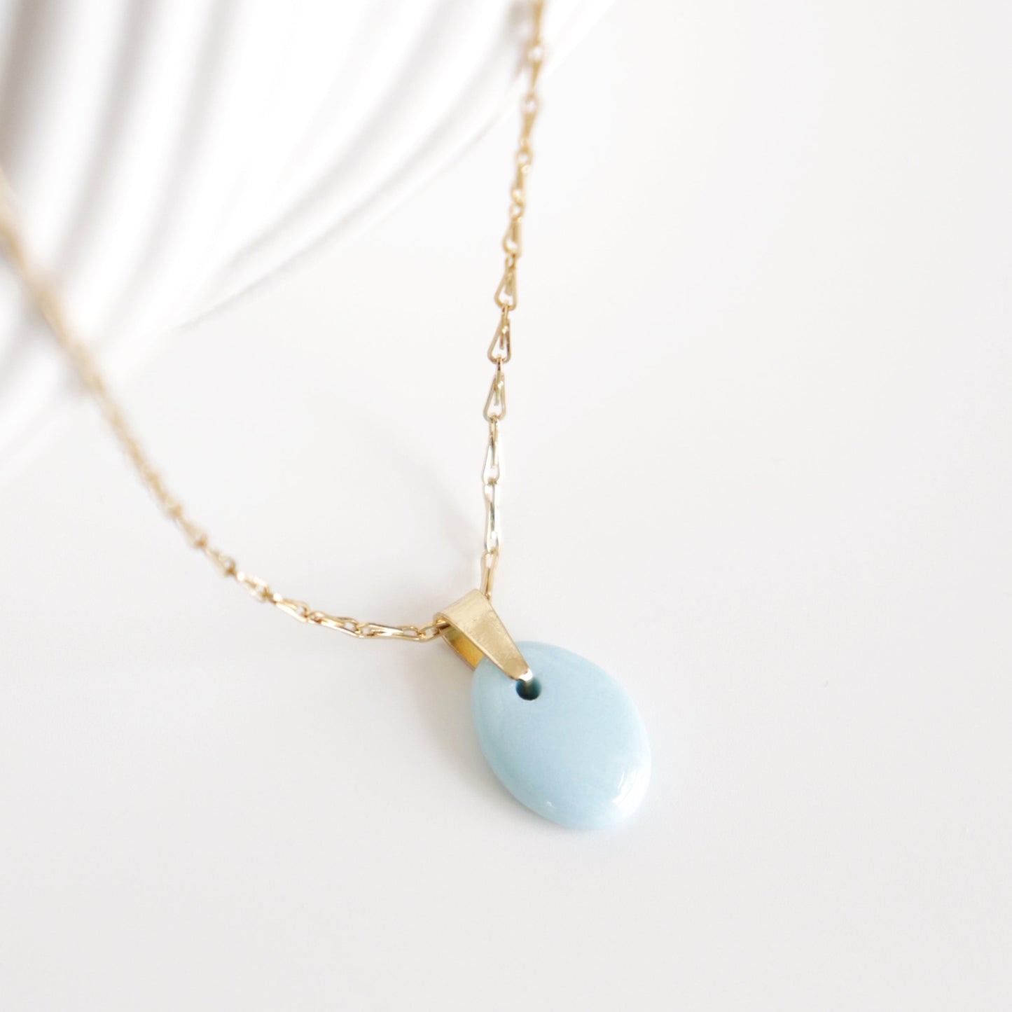 Necklace with a light blue pendant on a white background