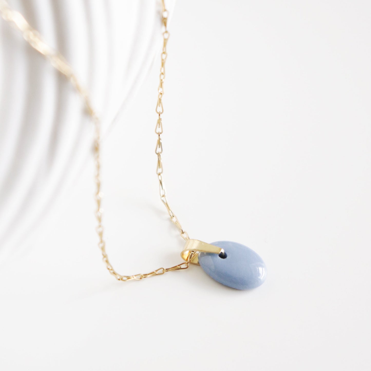 Necklace with a blue teardrop pendant on a white background