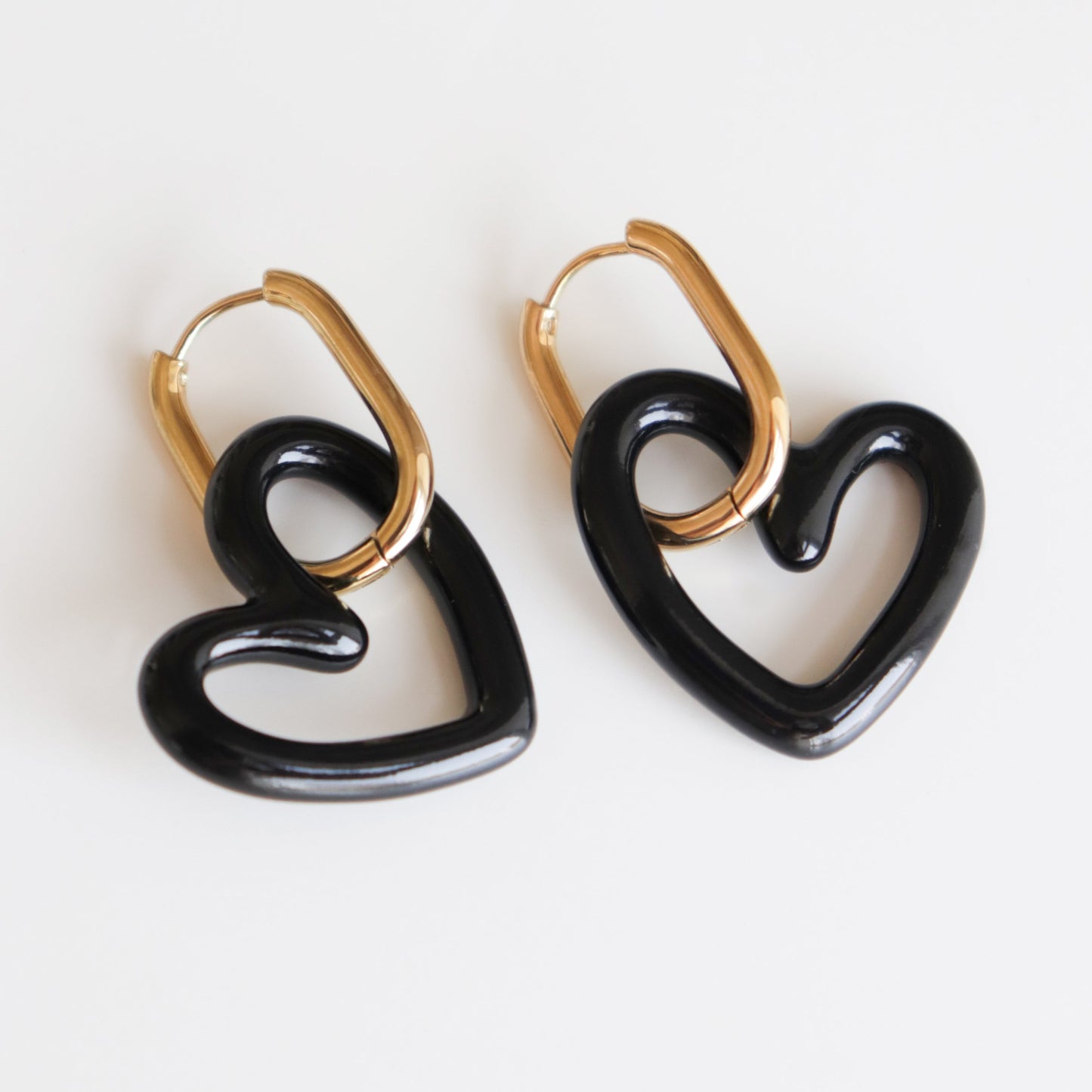 Heart Earrings by Rozenthal Jewelry: Handmade in Latvia, these gold hoops feature large black heart-shaped pendants, shown on a white background.