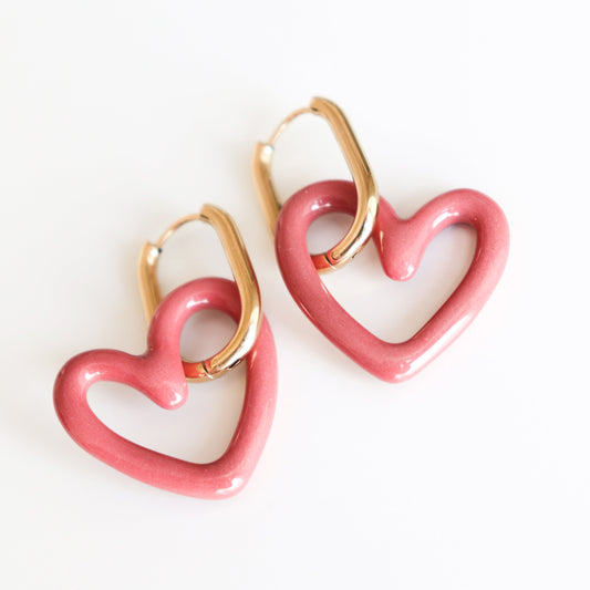 The Heart Earrings by Rozenthal Jewelry are lightweight, waterproof gold hoops with large pink heart-shaped charms, shown on a white background.