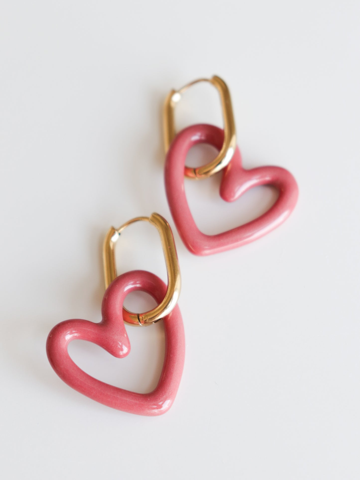 Heart Earrings by Rozenthal Jewelry are lightweight, waterproof gold hoops with pink heart-shaped charms, handmade and shown on a white background.