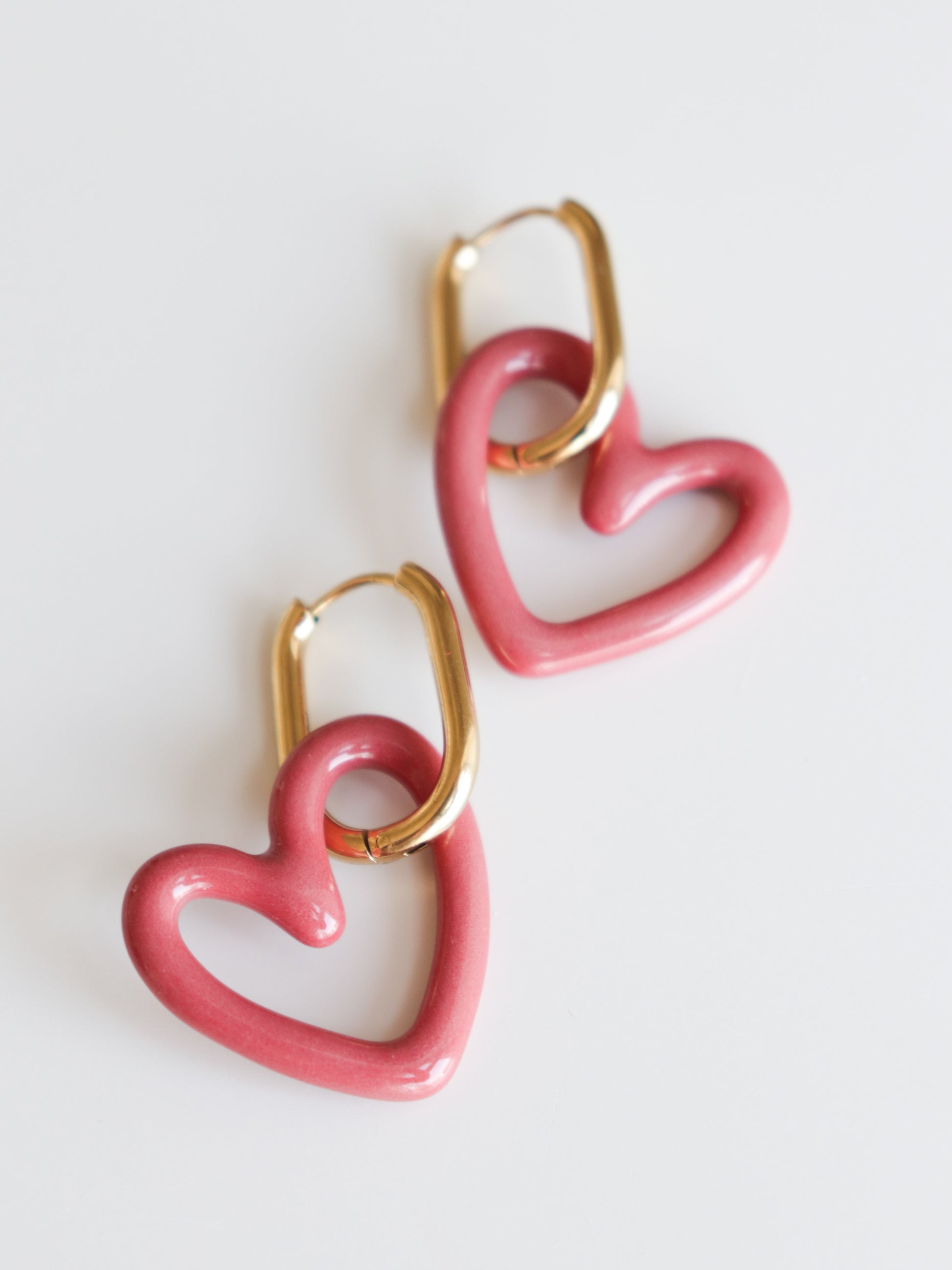 Heart Earrings by Rozenthal Jewelry are lightweight, waterproof gold hoops with pink heart-shaped charms, handmade and shown on a white background.