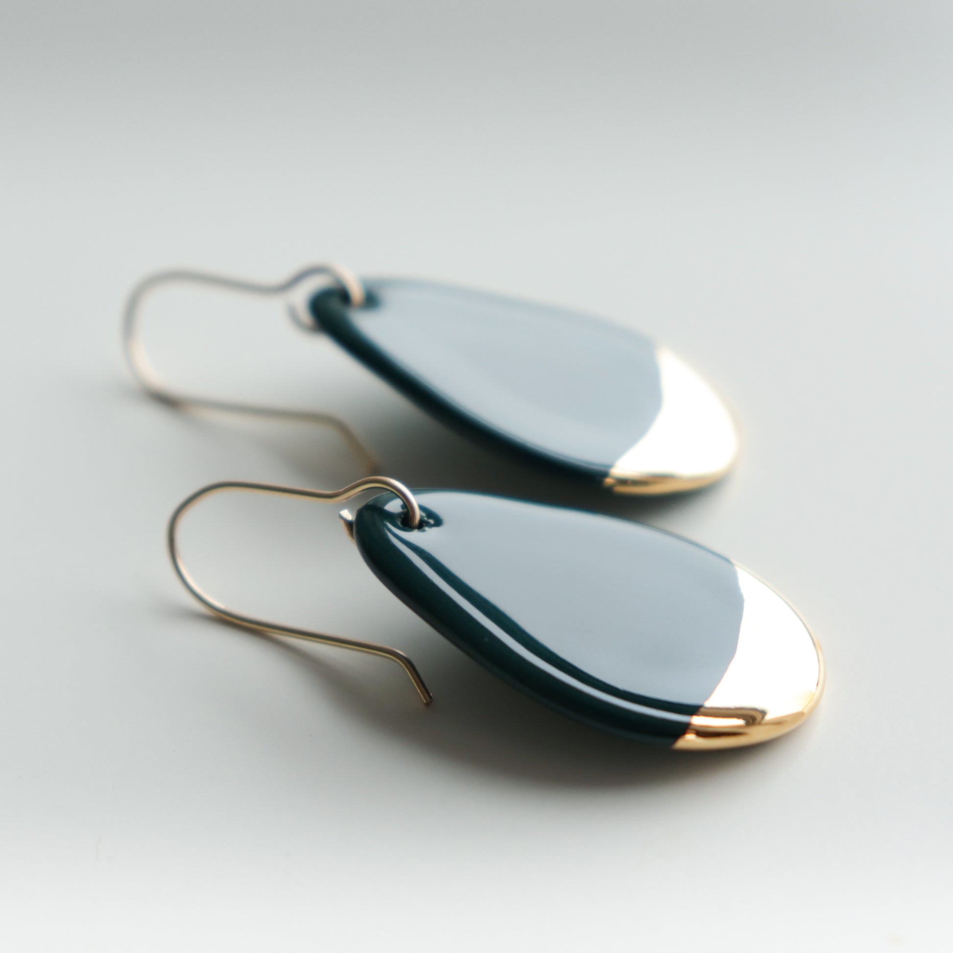 Drop Earrings / S by Rozenthal Jewelry: teardrop-shaped earrings with glossy dark blue enamel and gold tips, featuring simple gold hooks. Displayed on a light background, theyre ideal for fans of minimalist jewelry.