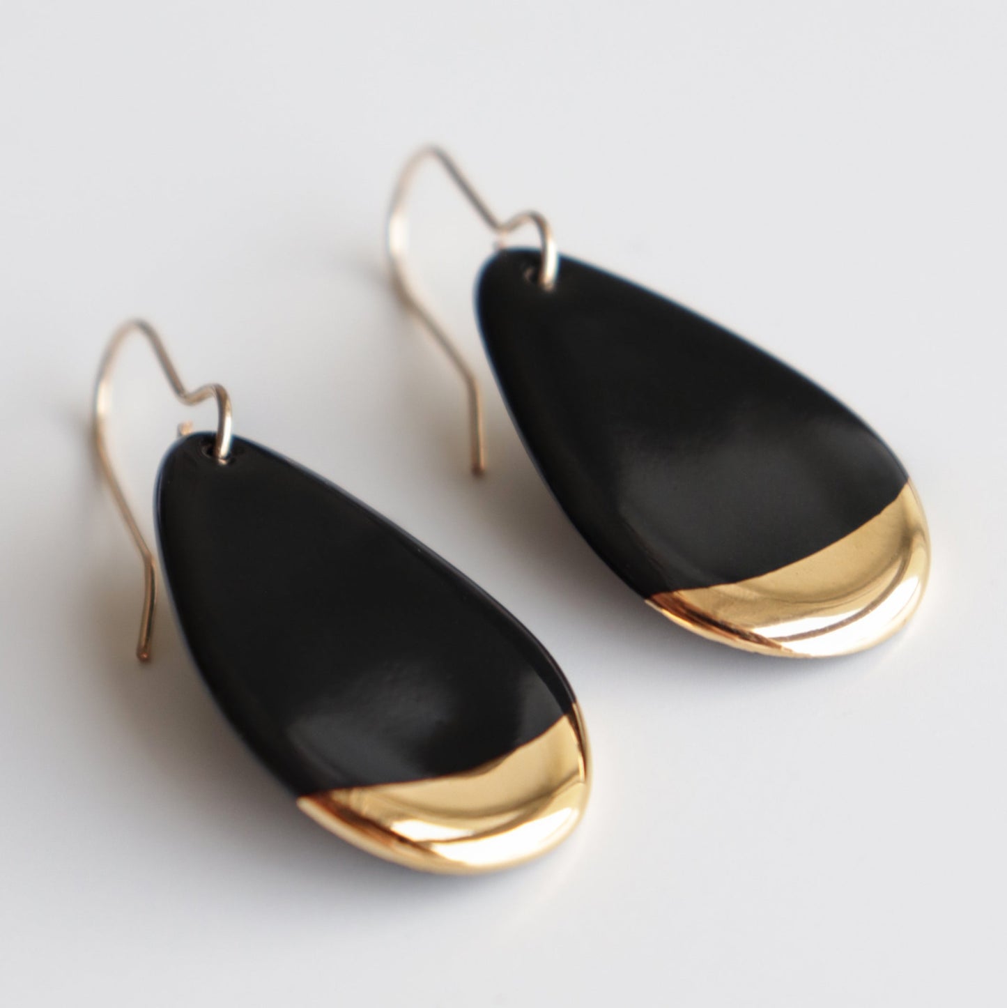 The Rozenthal Jewelry Drop Earrings / S feature a teardrop shape with a glossy black finish and gold accents at the bottom, crafted as minimalist jewelry and displayed on a white background.