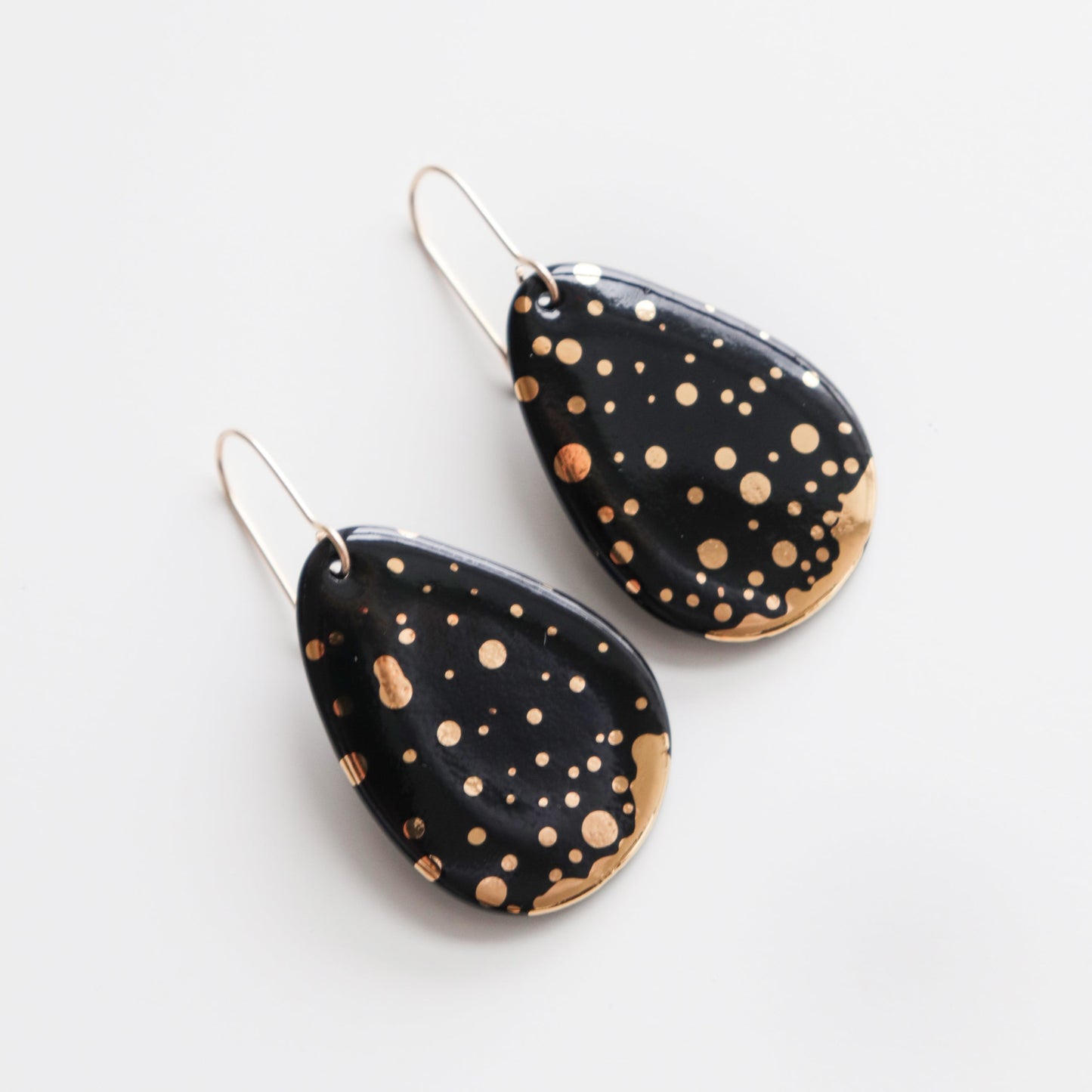 Rozenthal Jewelrys Drop Earrings / M feature handmade teardrop shapes with a glossy black finish and gold splatter, shown on a white background.