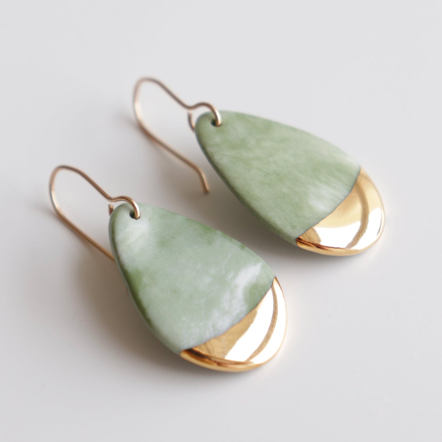Rozenthal Jewelrys Drop Earrings / S feature teardrop-shaped, handmade designs with light green stones and gold accents at the bottom, displayed on a white surface.