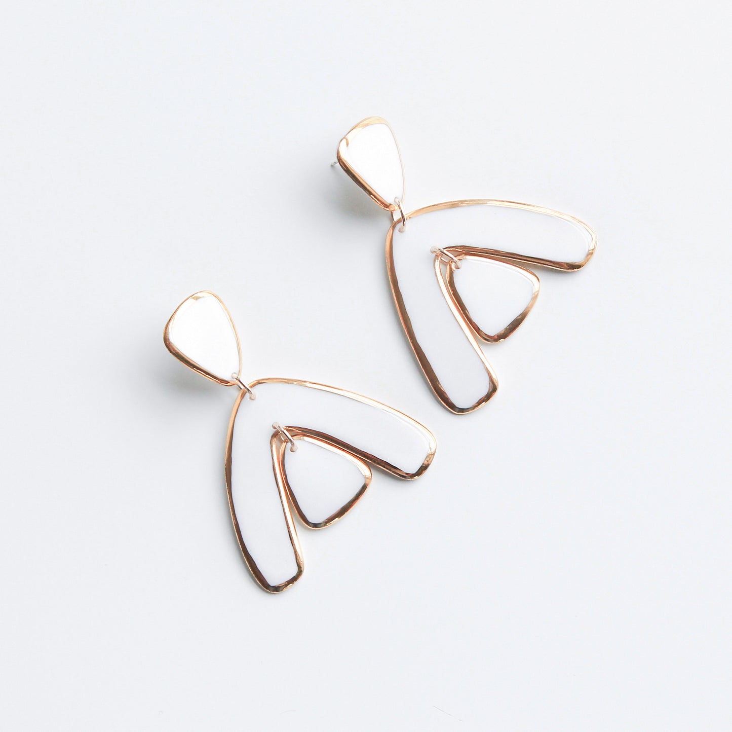 The Arquus Earrings by Rozenthal Jewelry are modern, abstract 24K gold earrings with open, curved shapes like stylized wings or leaves—a stunning example of handmade jewelry, shown on a plain white background.