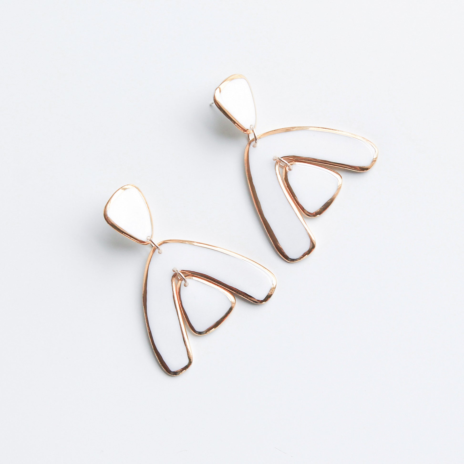The Arquus Earrings by Rozenthal Jewelry are modern, abstract 24K gold earrings with open, curved shapes like stylized wings or leaves—a stunning example of handmade jewelry, shown on a plain white background.