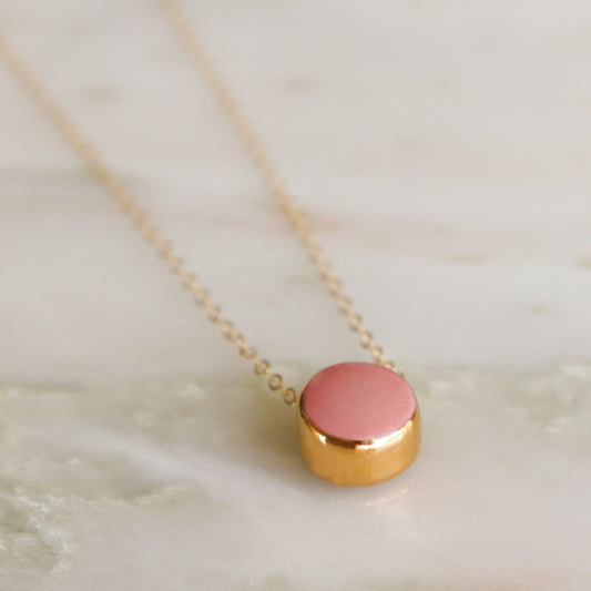 The Round Necklace by Rozenthal Jewelry is a minimalist gold chain with a small round pendant, shown elegantly on a light marble surface.