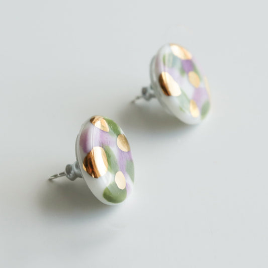The Tache Studs / S by Rozenthal Jewelry are round handmade earrings with a glossy white base, gold dots, and green-purple accents. Lightweight, waterproof, and ideal for everyday wear. Shown on a light background.