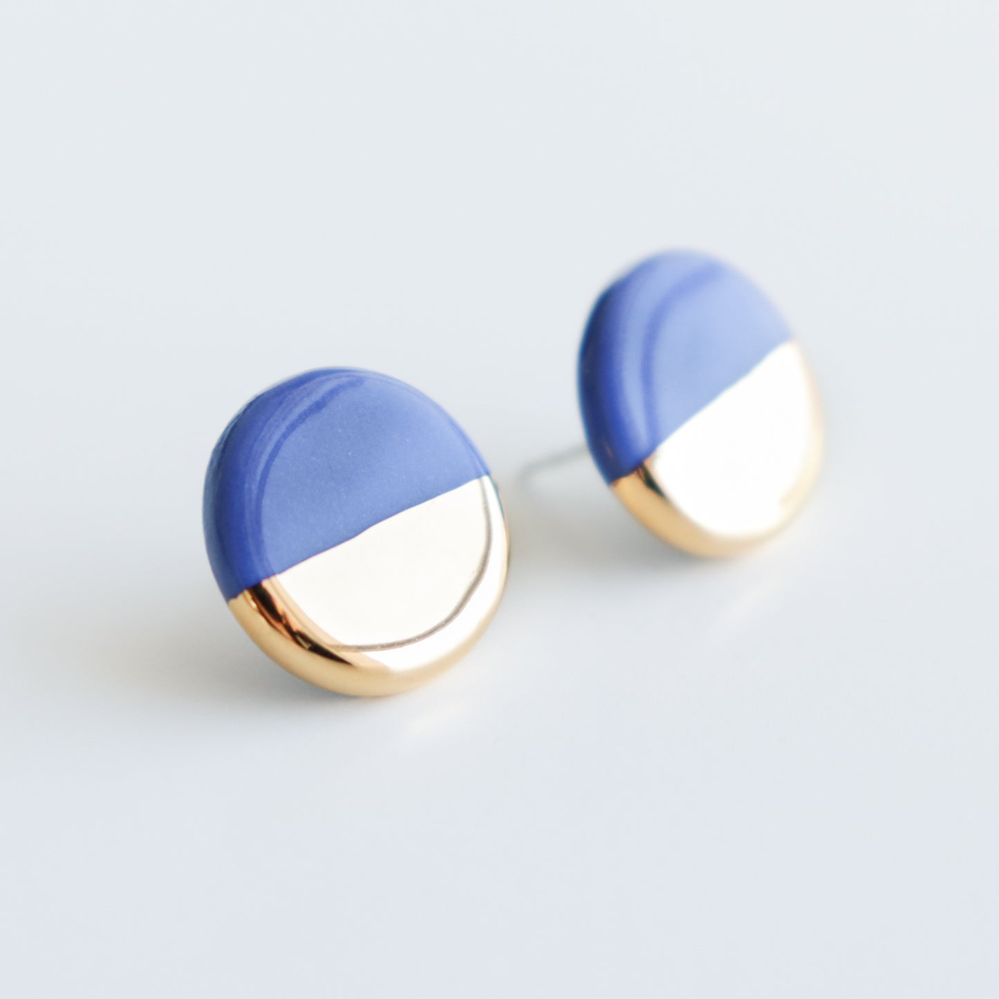 Rozenthal Jewelrys Round Studs / XS feature a minimalist half gold, half matte blue design, highlighting understated elegance against a plain white background.