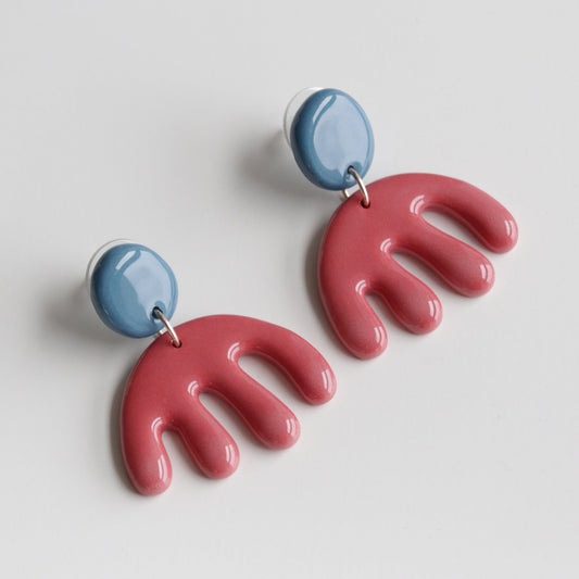 The Matisse Earrings by Rozenthal Jewelry feature glossy blue circular studs and red fan-shaped dangles. Handmade in Latvia, these stunning hypoallergenic designer earrings are shown on a white background.
