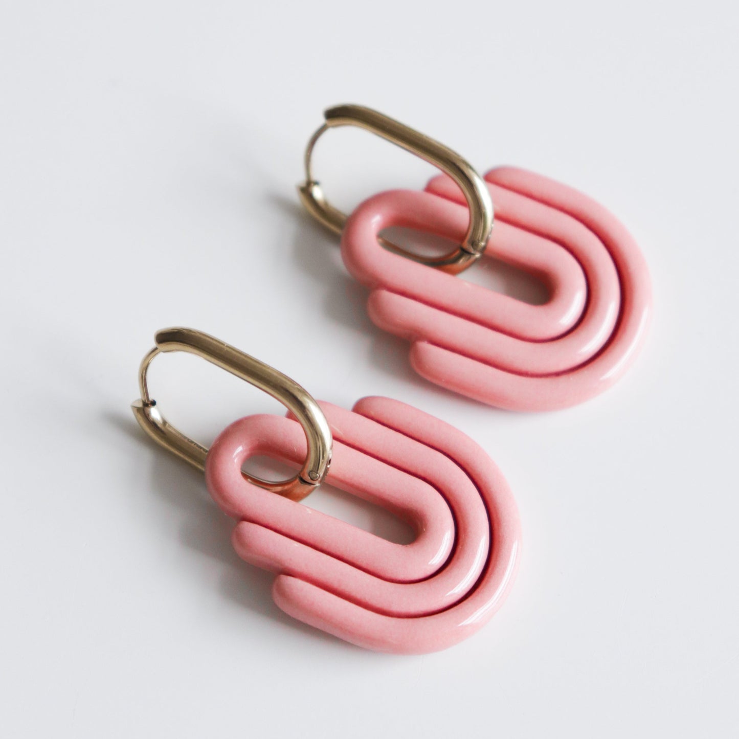 Art Deco Earrings by Rozenthal Jewelry: pink geometric interlocking hoops with gold ear hooks, handmade and shown on a white background.