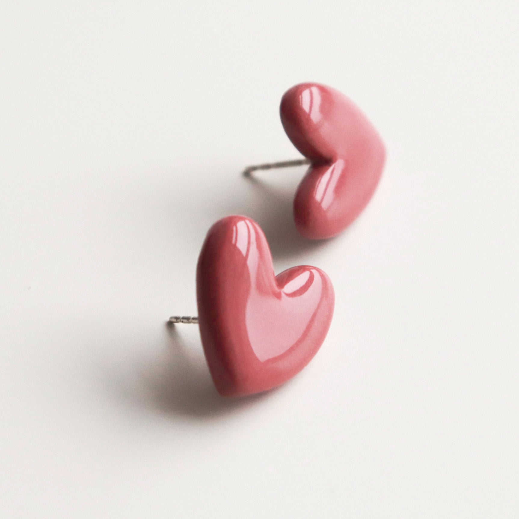 Heart Studs by Rozenthal Jewelry: pink, glossy, heart-shaped hypoallergenic designer earrings displayed on a white background.