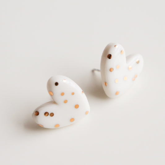 Heart Studs by Rozenthal Jewelry—white, heart-shaped designer earrings with gold polka dots. Hypoallergenic and displayed on a white background.