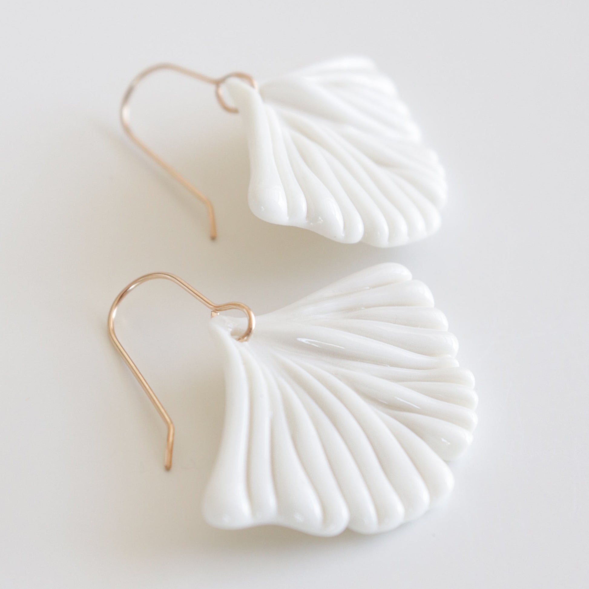 White ginkgo shaped earrings with gold hooks