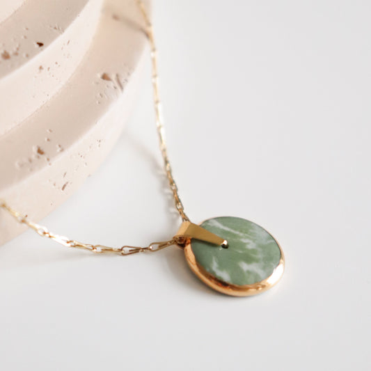 Necklace with a green pendant on a light background