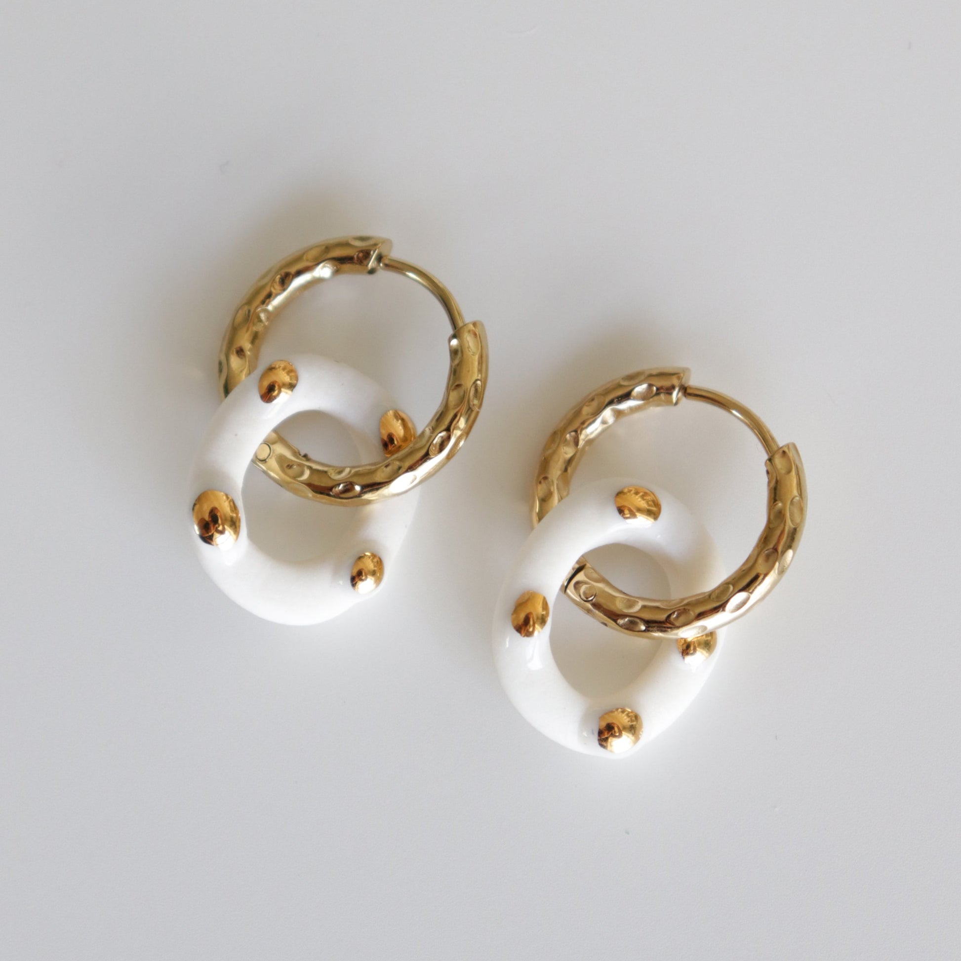 Pair of white round porcelain hoop earrings with gold drops