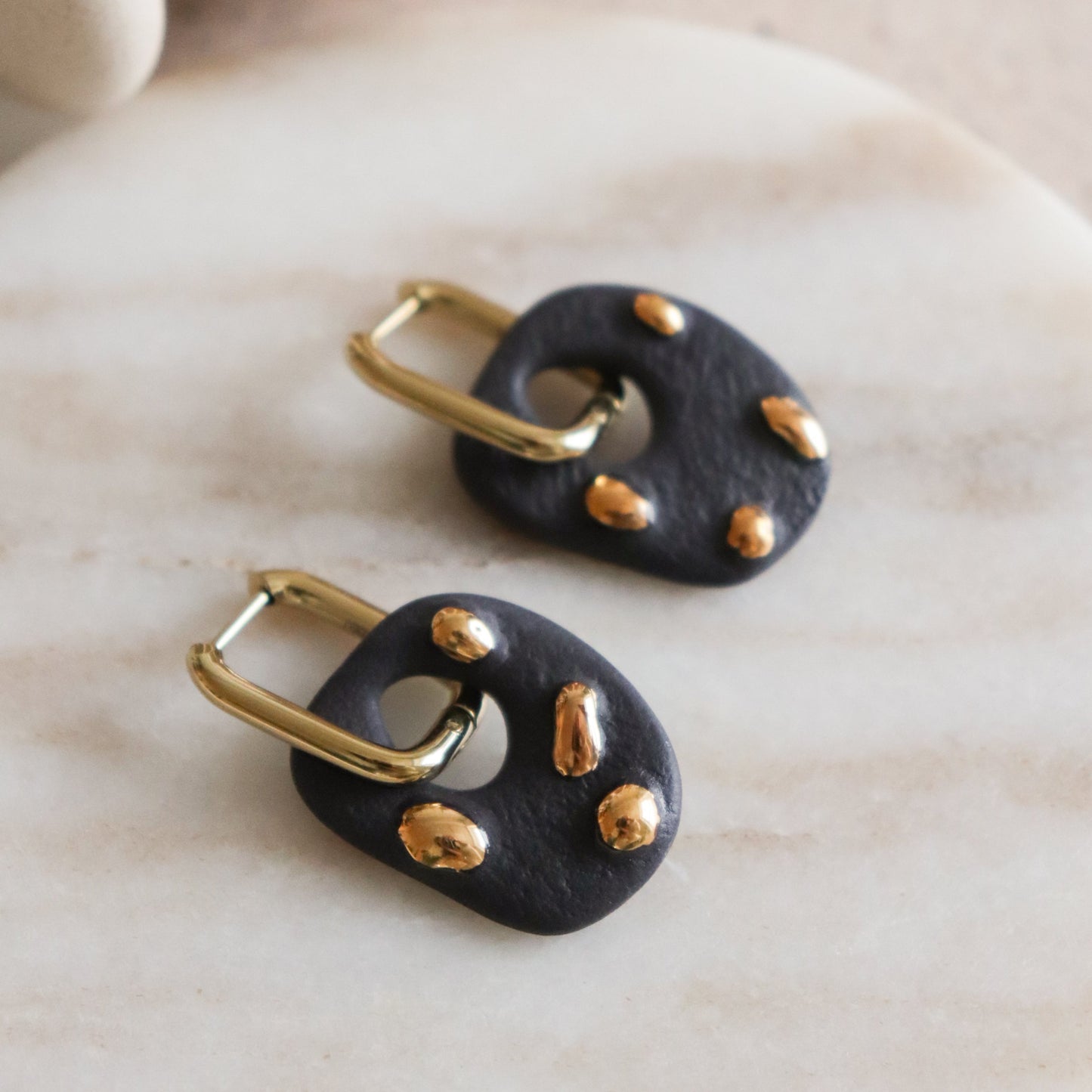 Black matte earrings with gold accents 