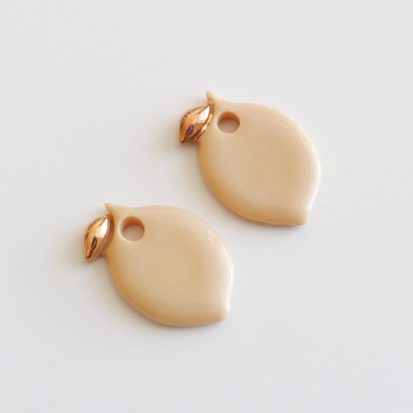 Pair of lemon shaped earrings on a light gray background