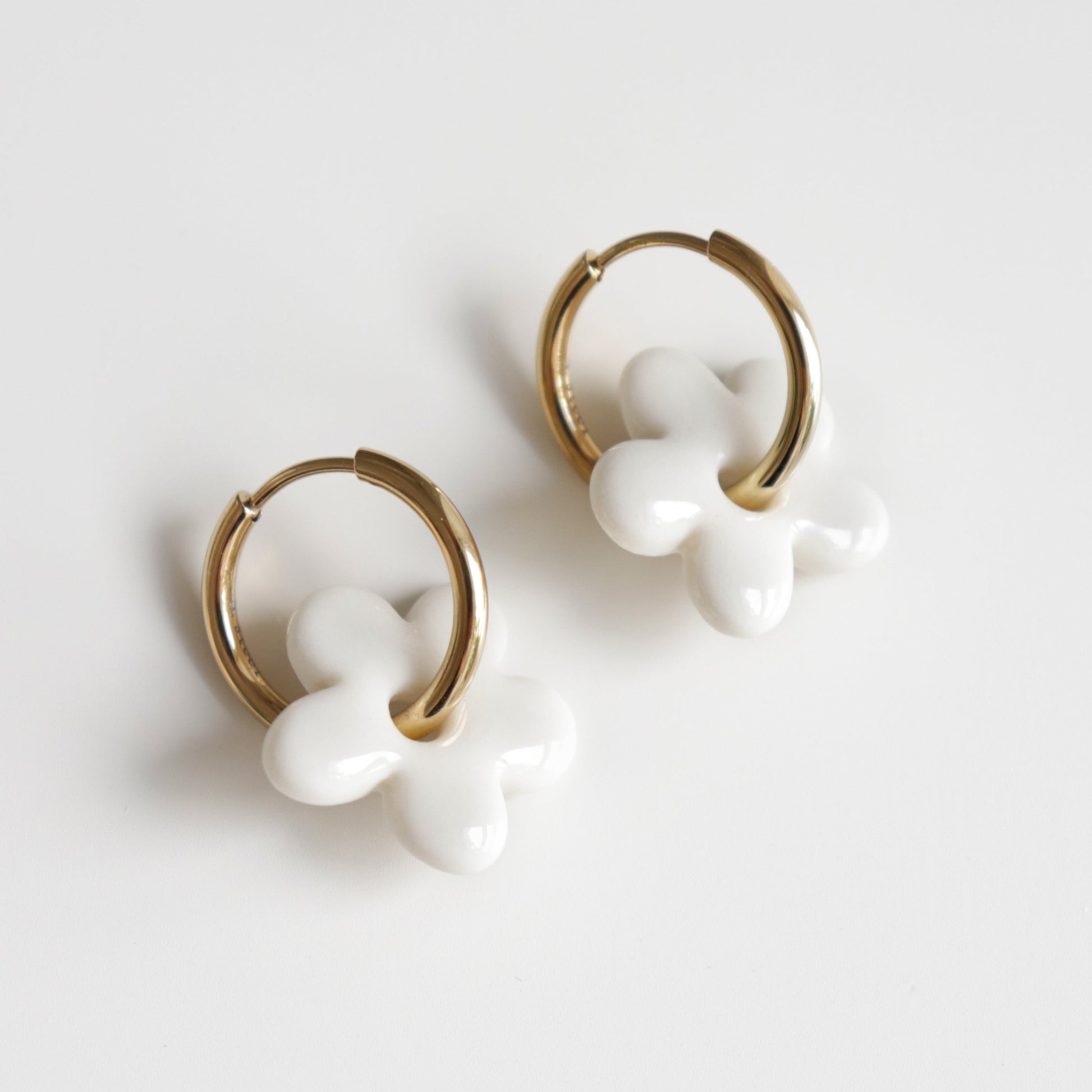 Pair of white flower earrings with gold hoops