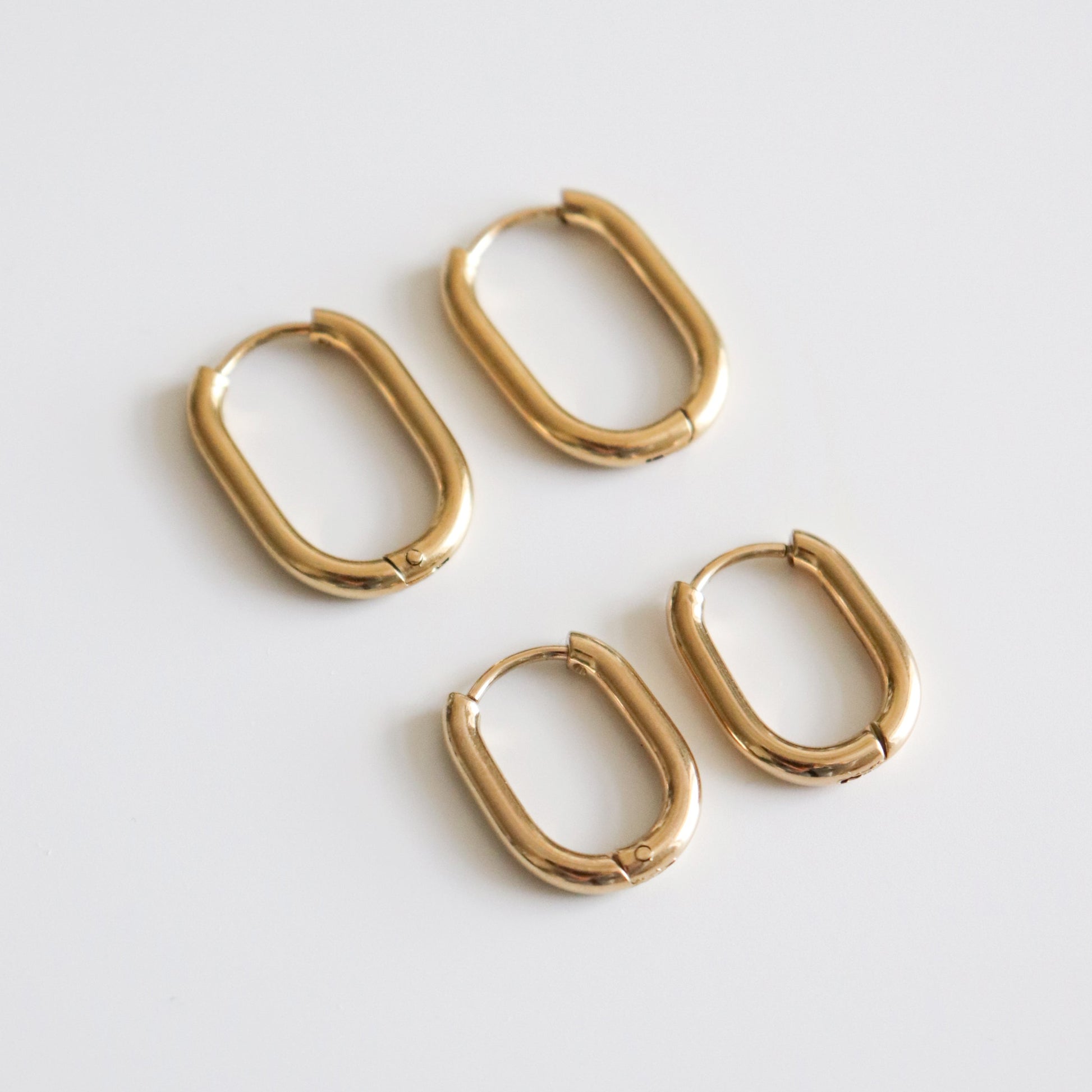 Set of gold hoop earrings on a light gray background
