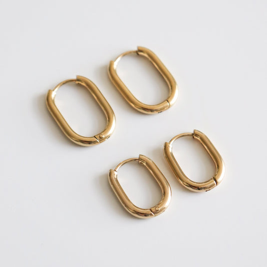Set of gold hoop earrings on a light gray background