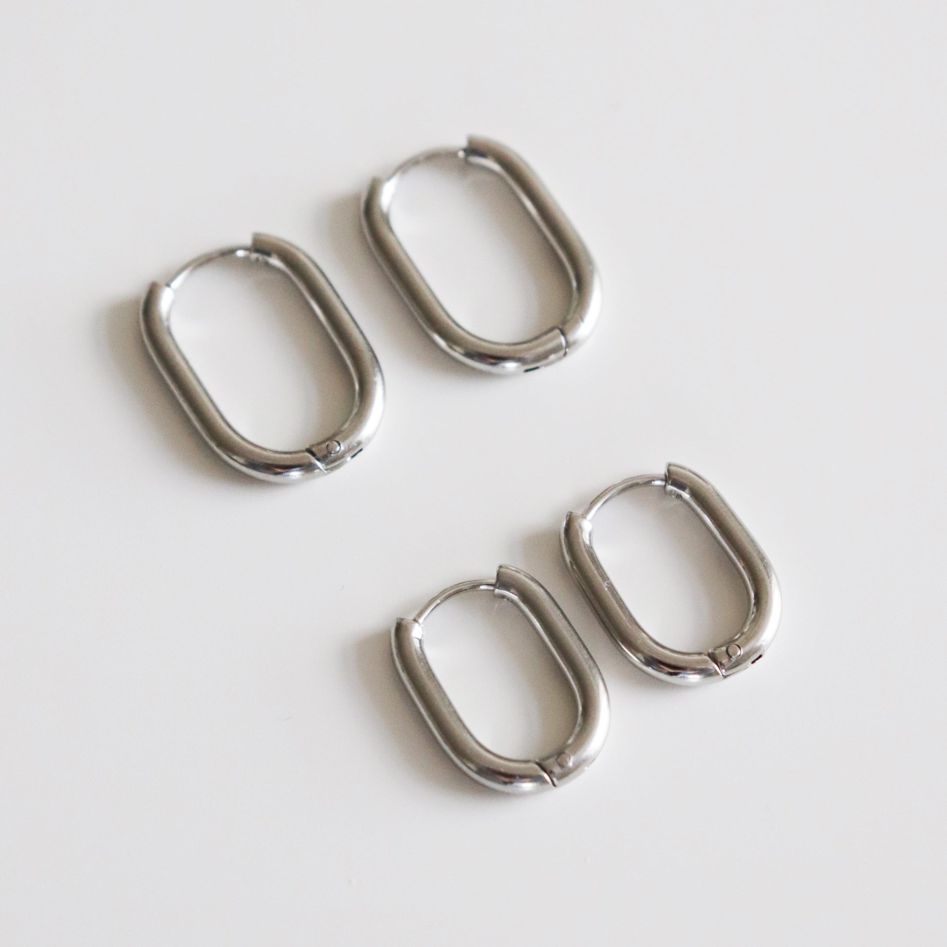 Set of four silver hoop earrings on a white background