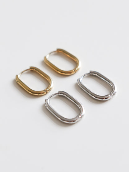 Two pairs of Rozenthal Jewelry Large Hoops—one gold, one silver—rest on a white surface. Crafted from hypoallergenic stainless steel, these earrings blend style and comfort.